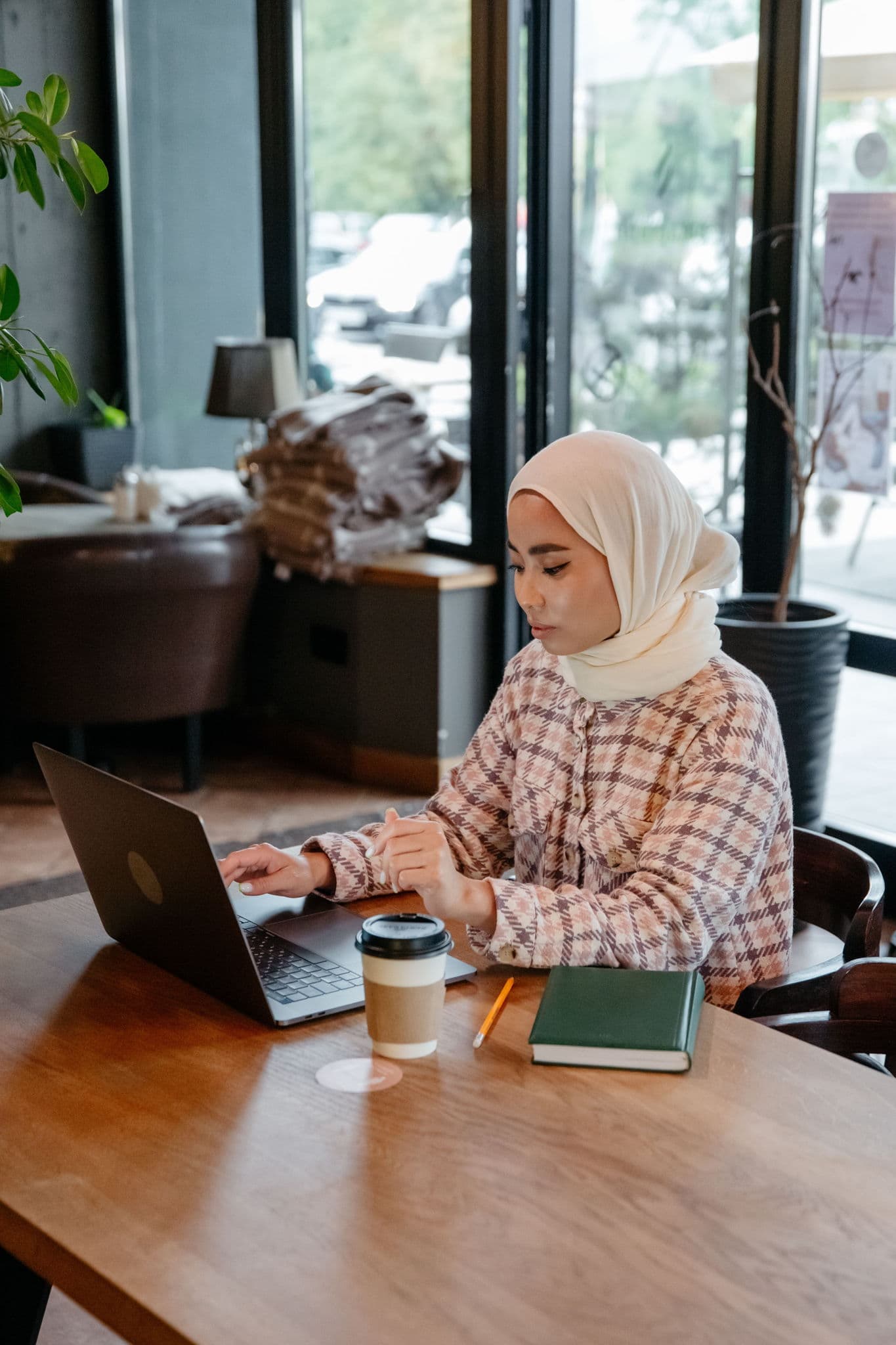 Restaurant owner checking email open rates on a laptop at the counter