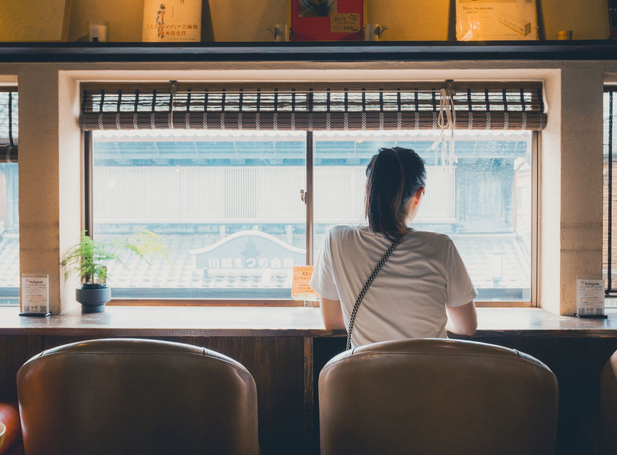 台灣餐廳離峰時段,一位顧客獨自坐在窗邊靜靜用餐,準備用排隊數據做離峰行銷
