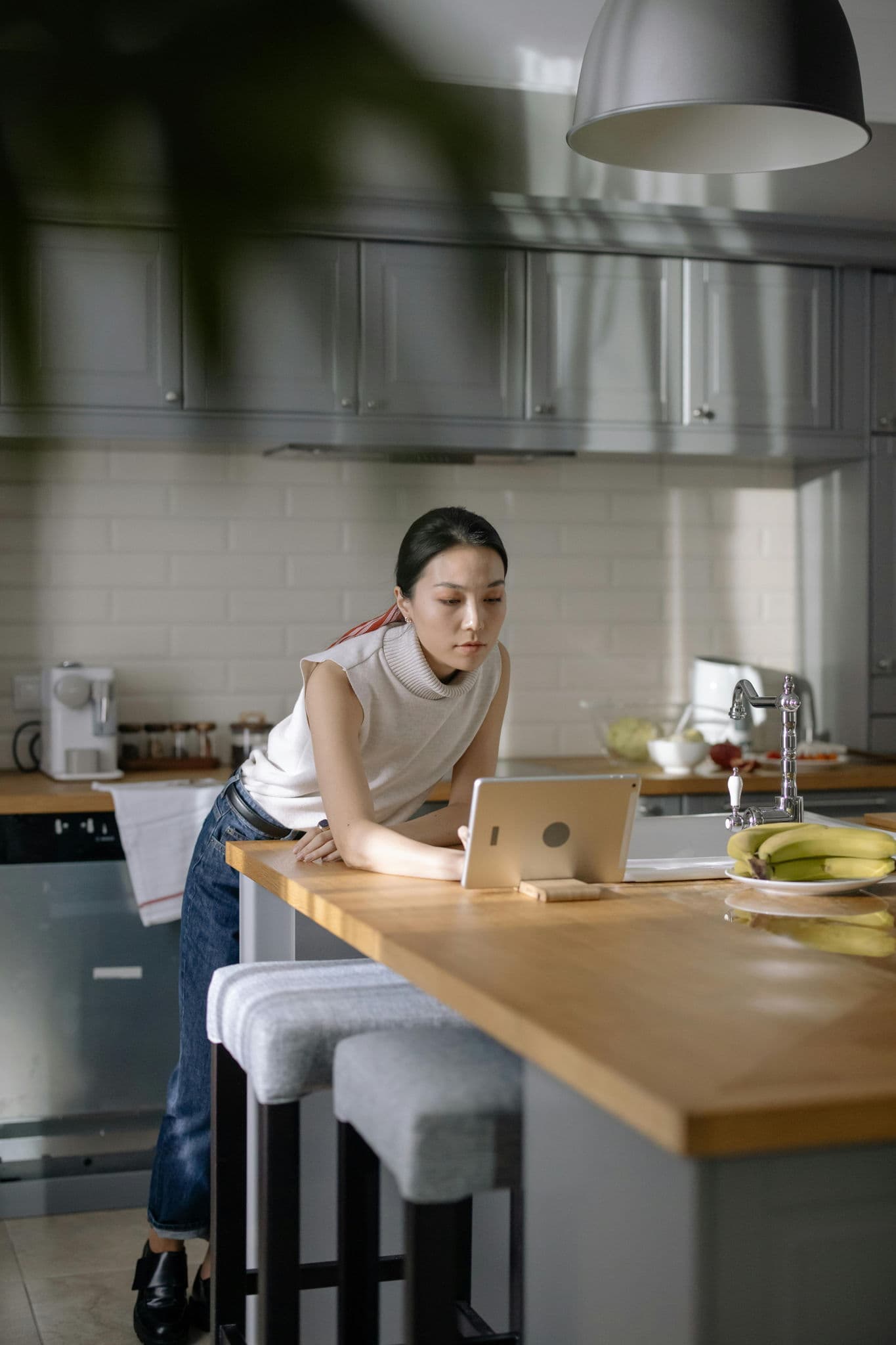 An independent restaurant owner checking guest messages on a tablet during a quiet moment at the counter