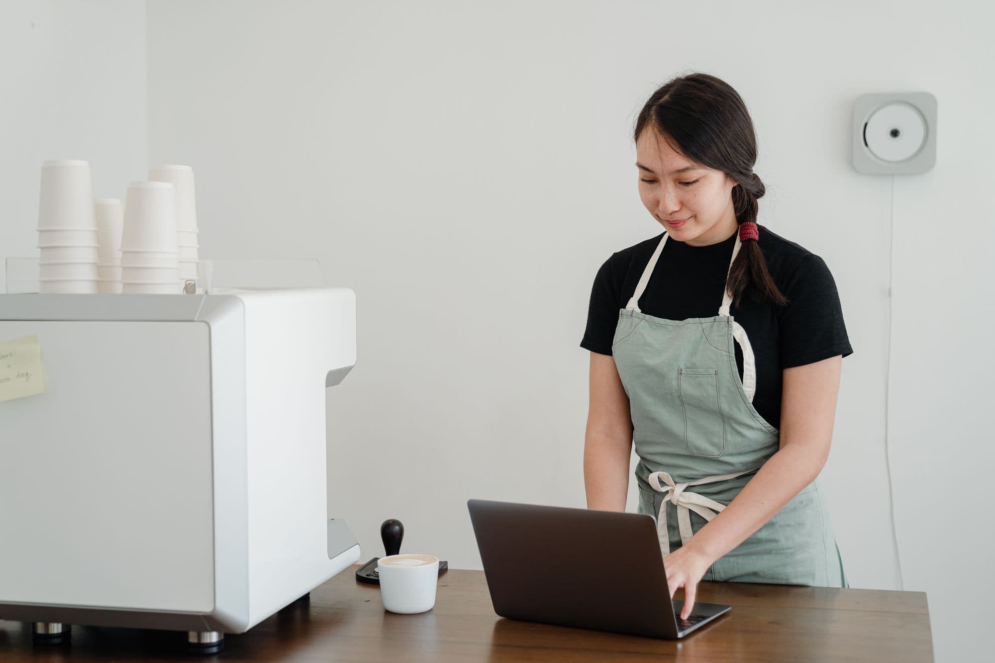 Restaurant owner comparing review-management tools on a laptop at the pass