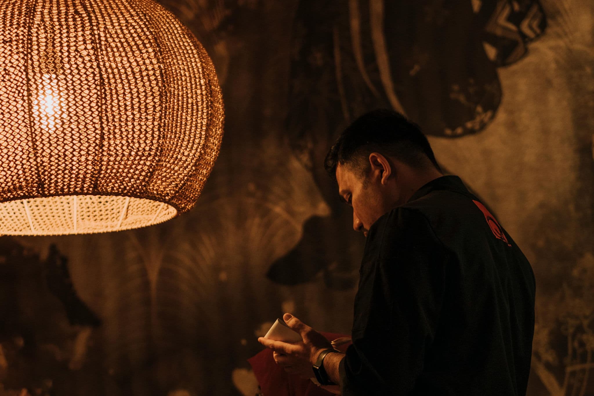 A restaurant host in a warm Singapore dining room at the start of service