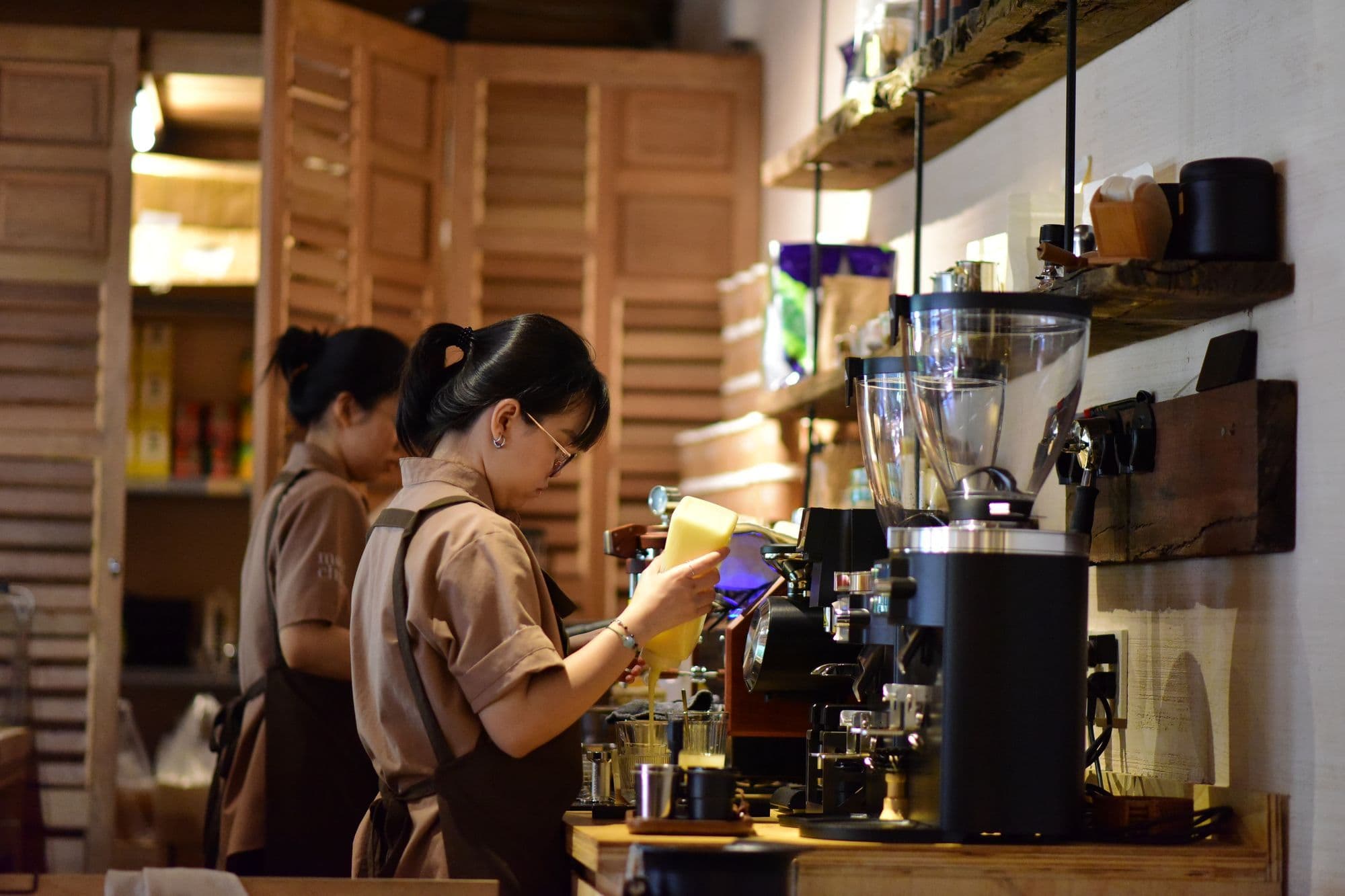 Two baristas brewing coffee at the counter of a newly opened cafe in Singapore