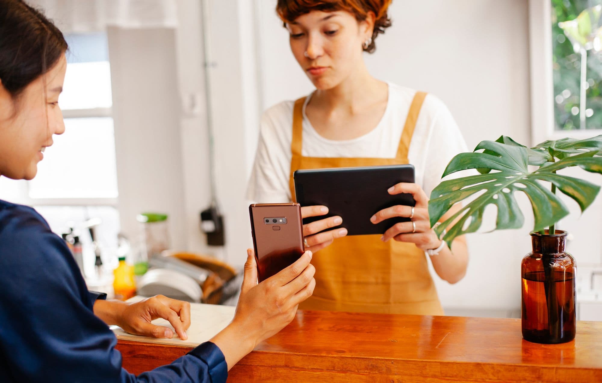 Restaurant owner replying to a Google review on a phone at the pass